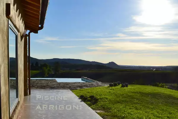 Piscina con sfioro a cascata su un lato lungo