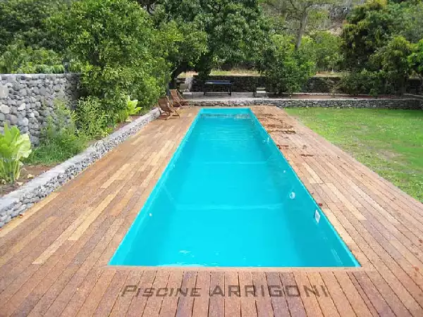 Piscina rettangolare lunga con marciapiede in legno