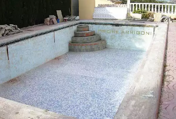 Piscina con pareti e mosaico malandati